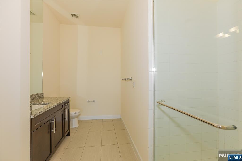 4 Main Street, Unit F Edgewater, NJ 07020 - Photo 11 of 20 a bathroom with a granite countertop sink a toilet and shower