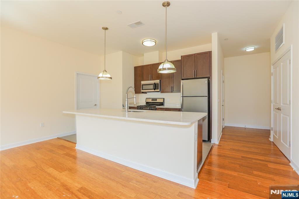 4 Main Street, Unit F Edgewater, NJ 07020 - Photo 5 of 20 a kitchen with stainless steel appliances granite countertop a refrigerator a sink and a stove