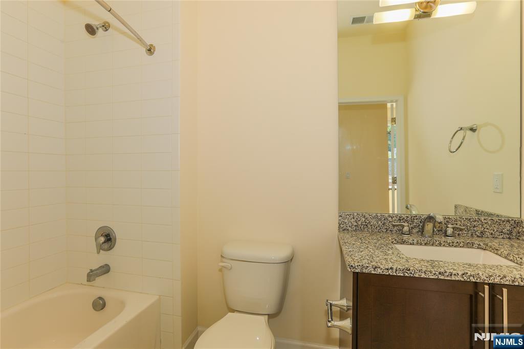 4 Main Street, Unit F Edgewater, NJ 07020 - Photo 10 of 20 a bathroom with a granite countertop sink a toilet and shower