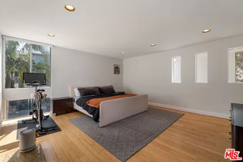 a bedroom with furniture and a large window