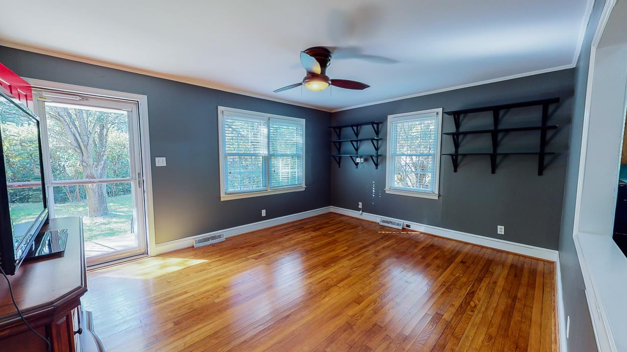 245 Howard Clayton Road Timberlake, NC 27583 - Photo 5 of 30 a view of empty room with wooden floor and fan