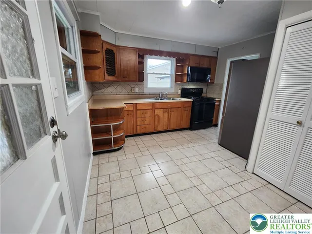 a large kitchen with a stove a refrigerator and a sink