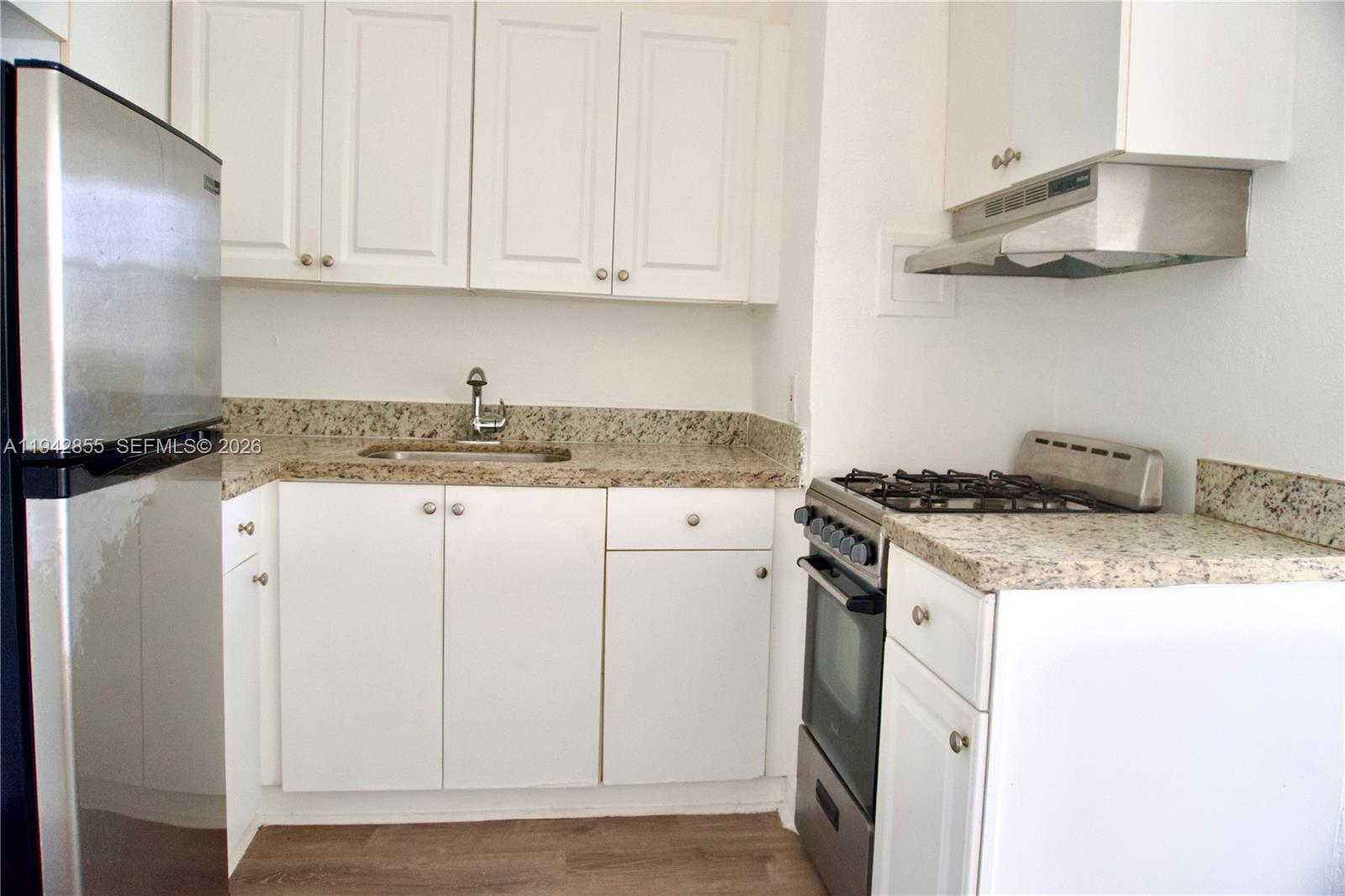 501 Southwest 6th Court, Unit 325 Miami, FL 33130 - Photo 13 of 25 a kitchen with granite countertop cabinets stainless steel appliances and a counter space