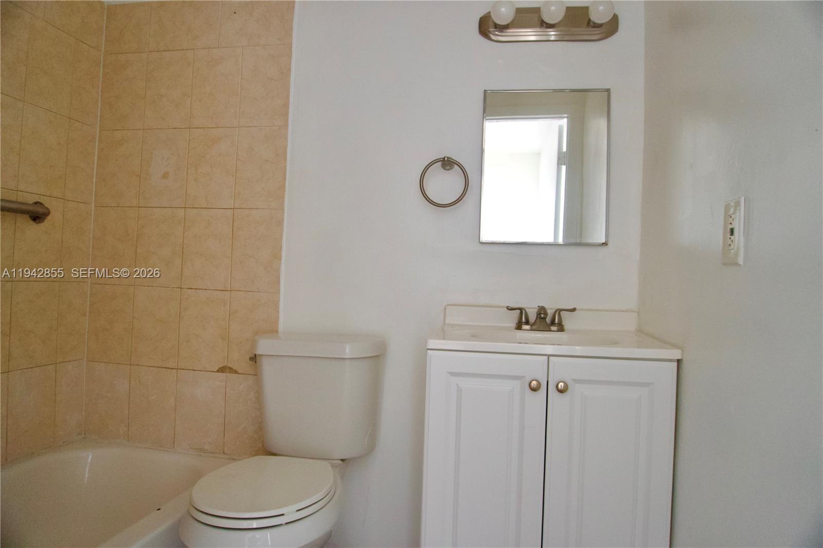 501 Southwest 6th Court, Unit 325 Miami, FL 33130 - Photo 14 of 25 a bathroom with a toilet a sink a mirror and bathtub