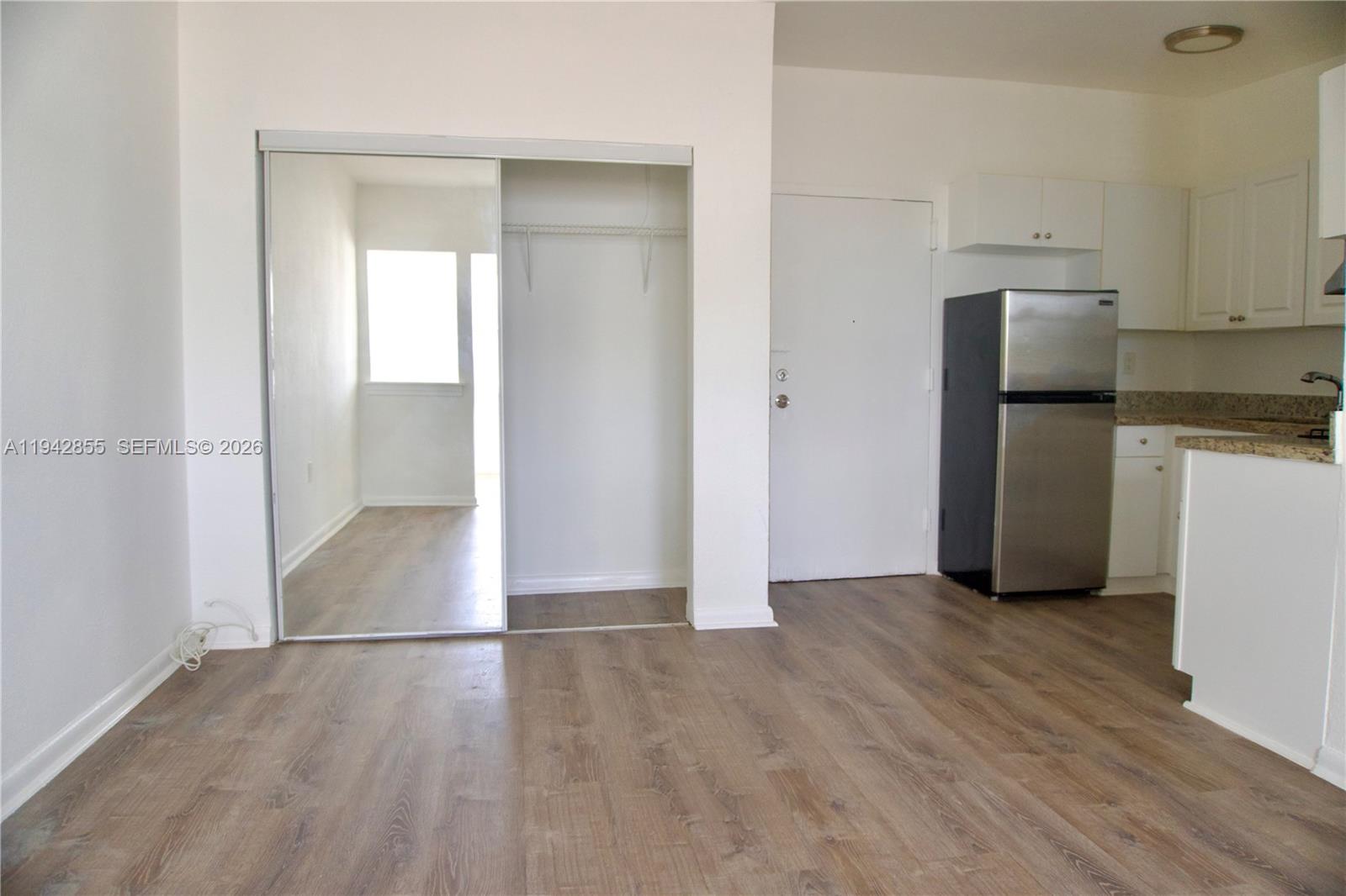 501 Southwest 6th Court, Unit 325 Miami, FL 33130 - Photo 4 of 25 a view of a kitchen with a refrigerator and wooden floor