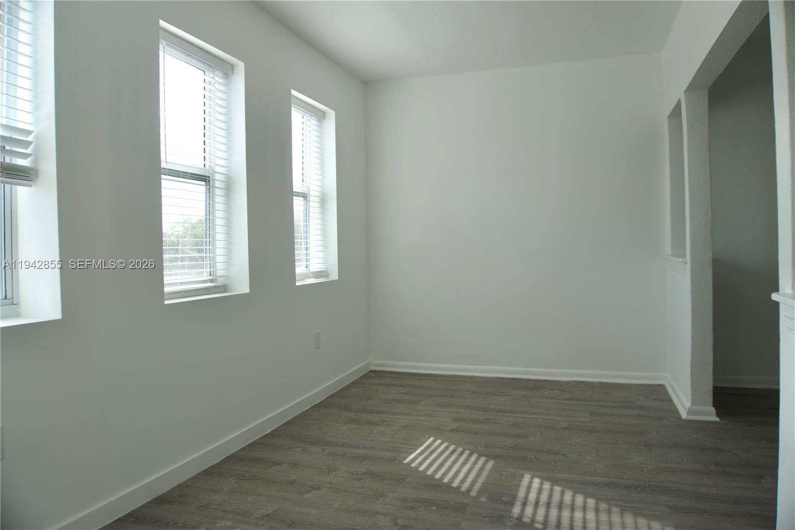 501 Southwest 6th Court, Unit 325 Miami, FL 33130 - Photo 6 of 25 an empty room with wooden floor and windows