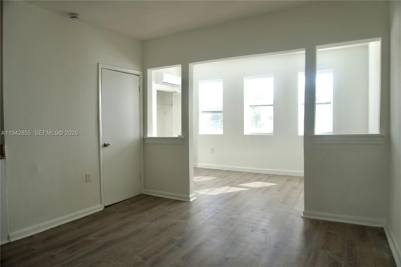 501 Southwest 6th Court, Unit 325 Miami, FL 33130 - Photo 9 of 25 an empty room with wooden floor and windows