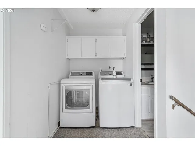 a utility room with cabinets washer and dryer