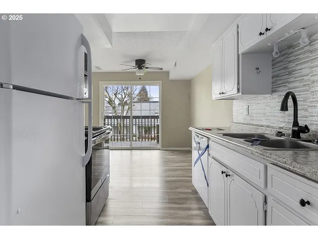 a kitchen with granite countertop a sink stainless steel appliances and cabinets