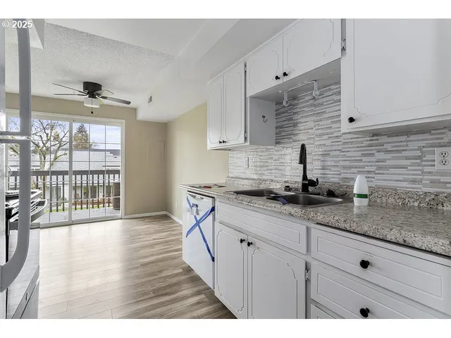 a kitchen with granite countertop a sink stainless steel appliances and cabinets