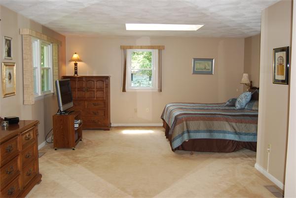 76 Joyce Road Framingham, MA 01701 - Photo 5 of 22 a bedroom with a bed and a chandelier