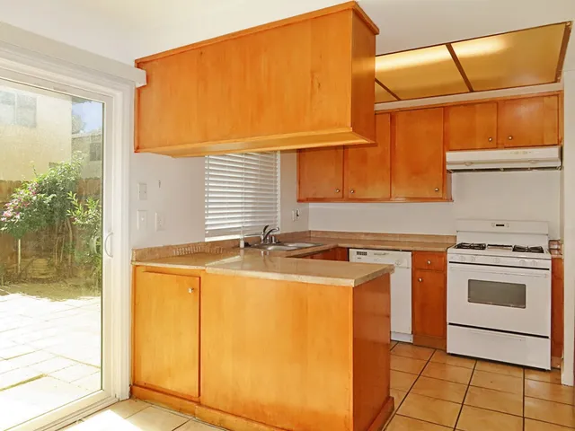 a kitchen with a sink a stove and cabinets