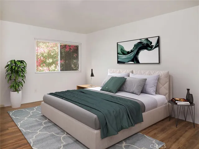 a bedroom with a bed and a painting on the wall