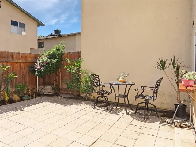 a view of a patio with table and chairs with wooden floor and plants
