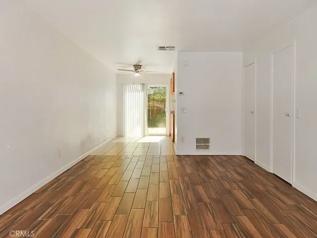 a view of an empty room with wooden floor