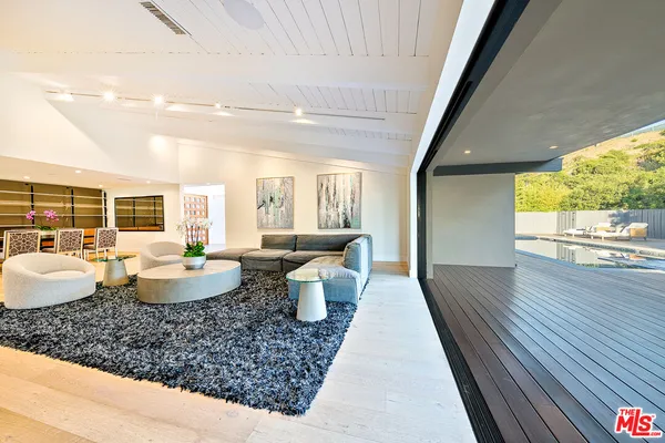 a large living room with patio furniture and a large window