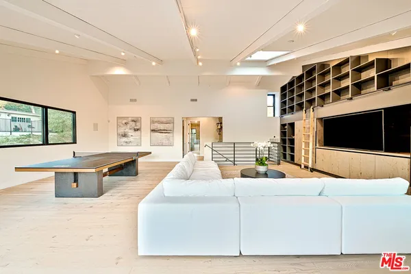 a living room with furniture a flat screen tv and a large window