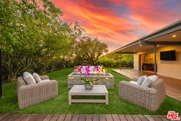 a patio with couch and a garden