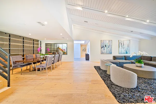 a living room with lots of furniture and view of kitchen