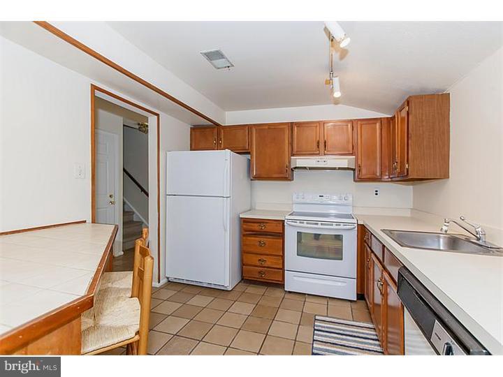 205 Chase Road Wayne, PA 19087 - Photo 9 of 23 a kitchen with a refrigerator a stove top oven and cabinets