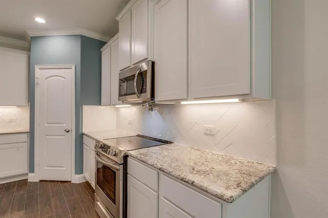 a kitchen with stainless steel appliances granite countertop a sink refrigerator and microwave