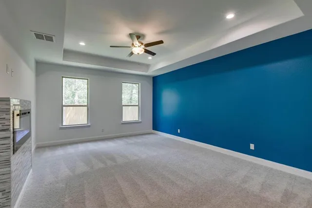 an empty room with closet and a ceiling fan