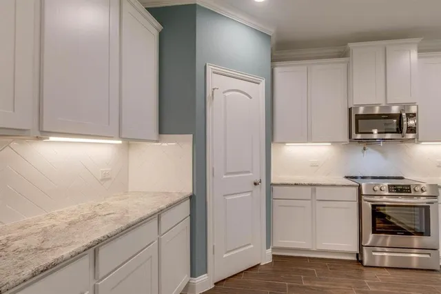 a kitchen with granite countertop cabinets stainless steel appliances and a sink
