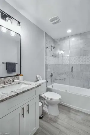 a bathroom with a sink a toilet and a large mirror