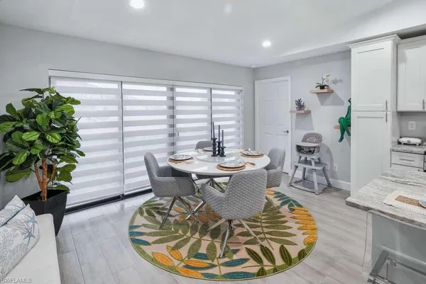 a dining room with furniture potted plants and wooden floor