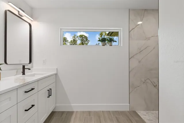 a bathroom with a granite countertop sink a vanity and mirror