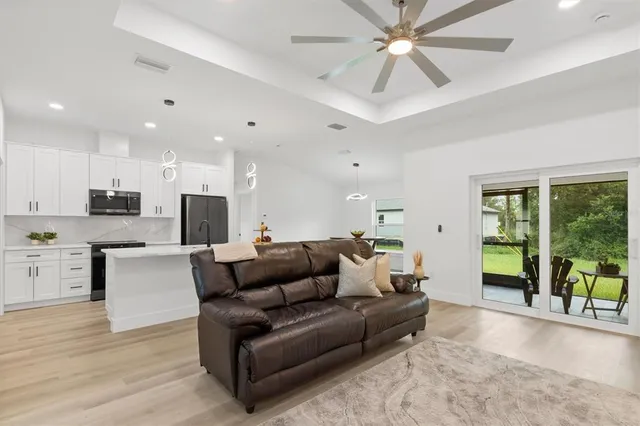 a living room with stainless steel appliances furniture and a open kitchen view