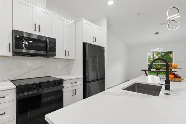 a kitchen with stainless steel appliances a stove microwave and refrigerator