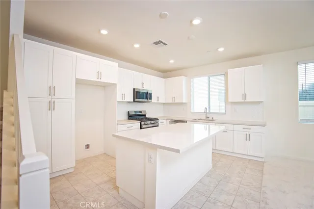 a kitchen with white cabinets and white appliances