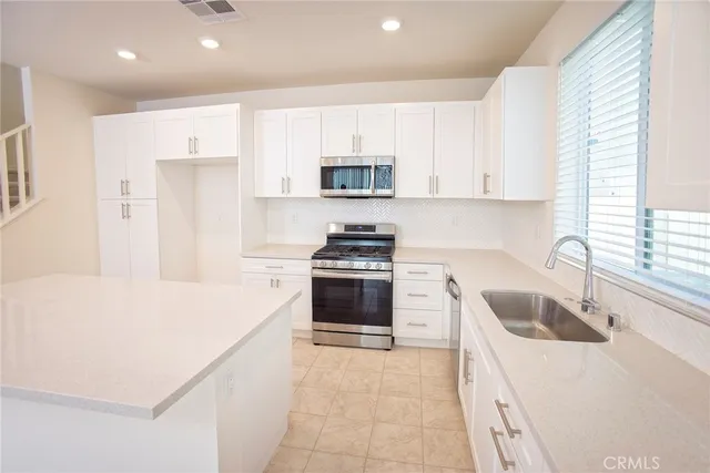a kitchen that has a sink and a stove top oven