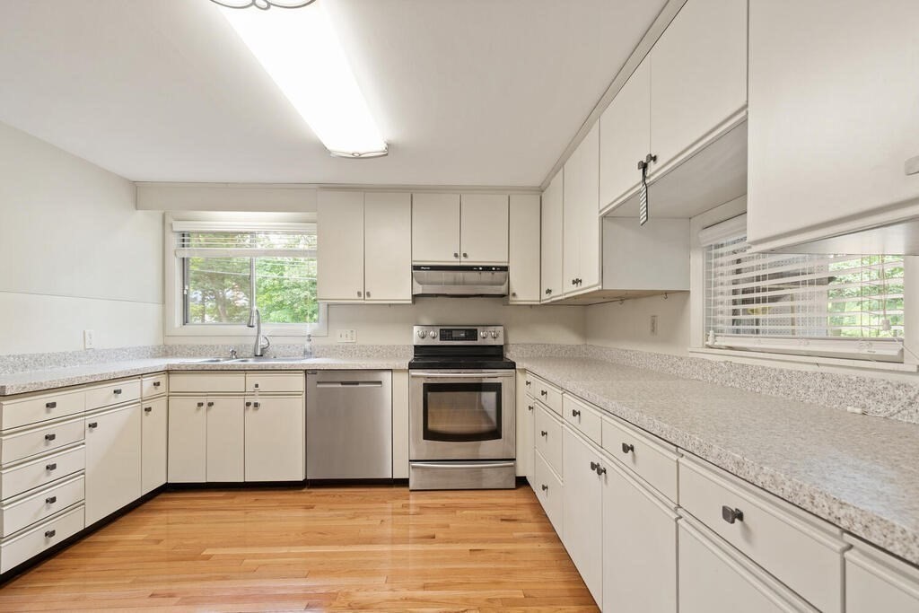 459 Winch Street Framingham, MA 01701 - Photo 17 of 34 a kitchen with granite countertop white cabinets and window