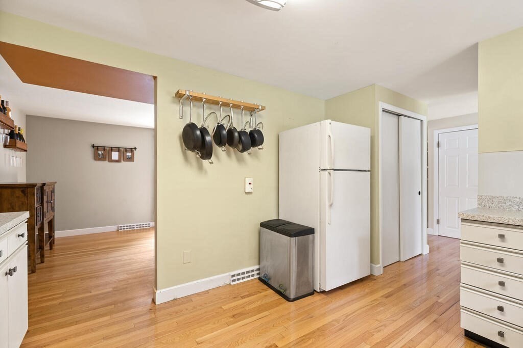 459 Winch Street Framingham, MA 01701 - Photo 18 of 34 a kitchen with a refrigerator a stove and a wooden floor