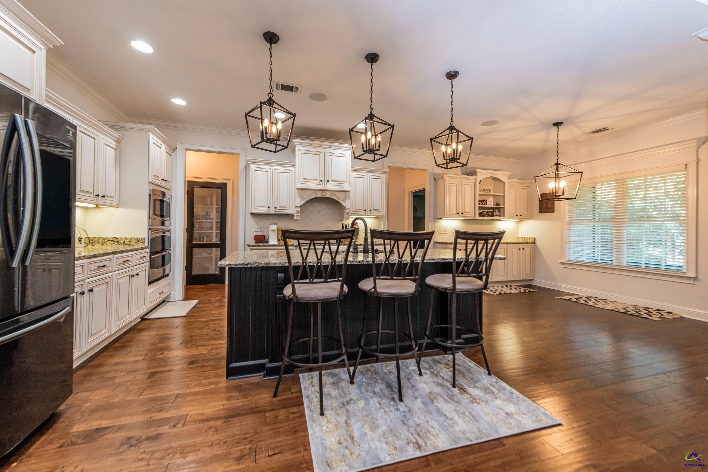 405 Old Bridge Road Warner Robins, GA 31088 - Photo 15 of 58 a kitchen with stainless steel appliances kitchen island granite countertop a table chairs stove and refrigerator