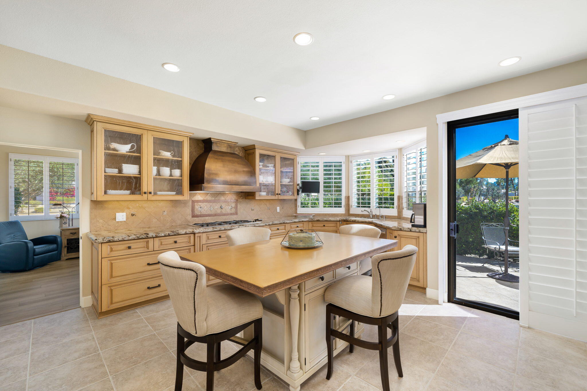 818 Inverness Drive Rancho Mirage, CA 92270 - Photo 19 of 43 a dining room with stainless steel appliances granite countertop a stove a sink a refrigerator a dining table and chairs with wooden floor