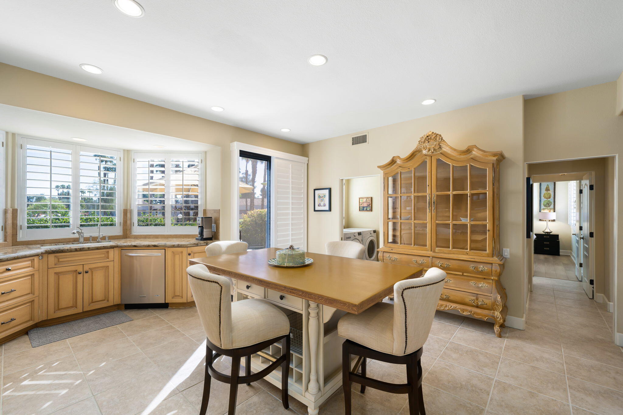 818 Inverness Drive Rancho Mirage, CA 92270 - Photo 20 of 43 a dining room with a wooden table and chairs