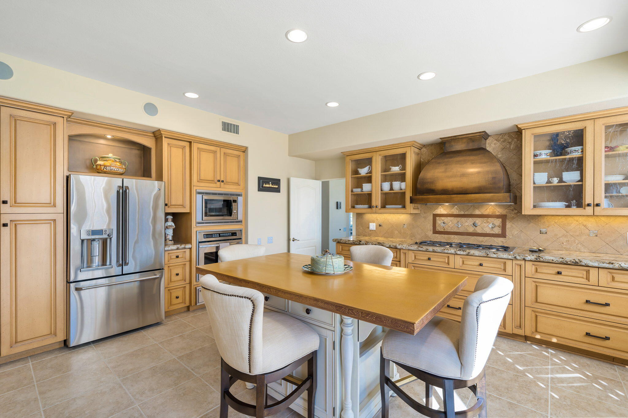 818 Inverness Drive Rancho Mirage, CA 92270 - Photo 22 of 43 a kitchen with a refrigerator a stove a dining table and chairs