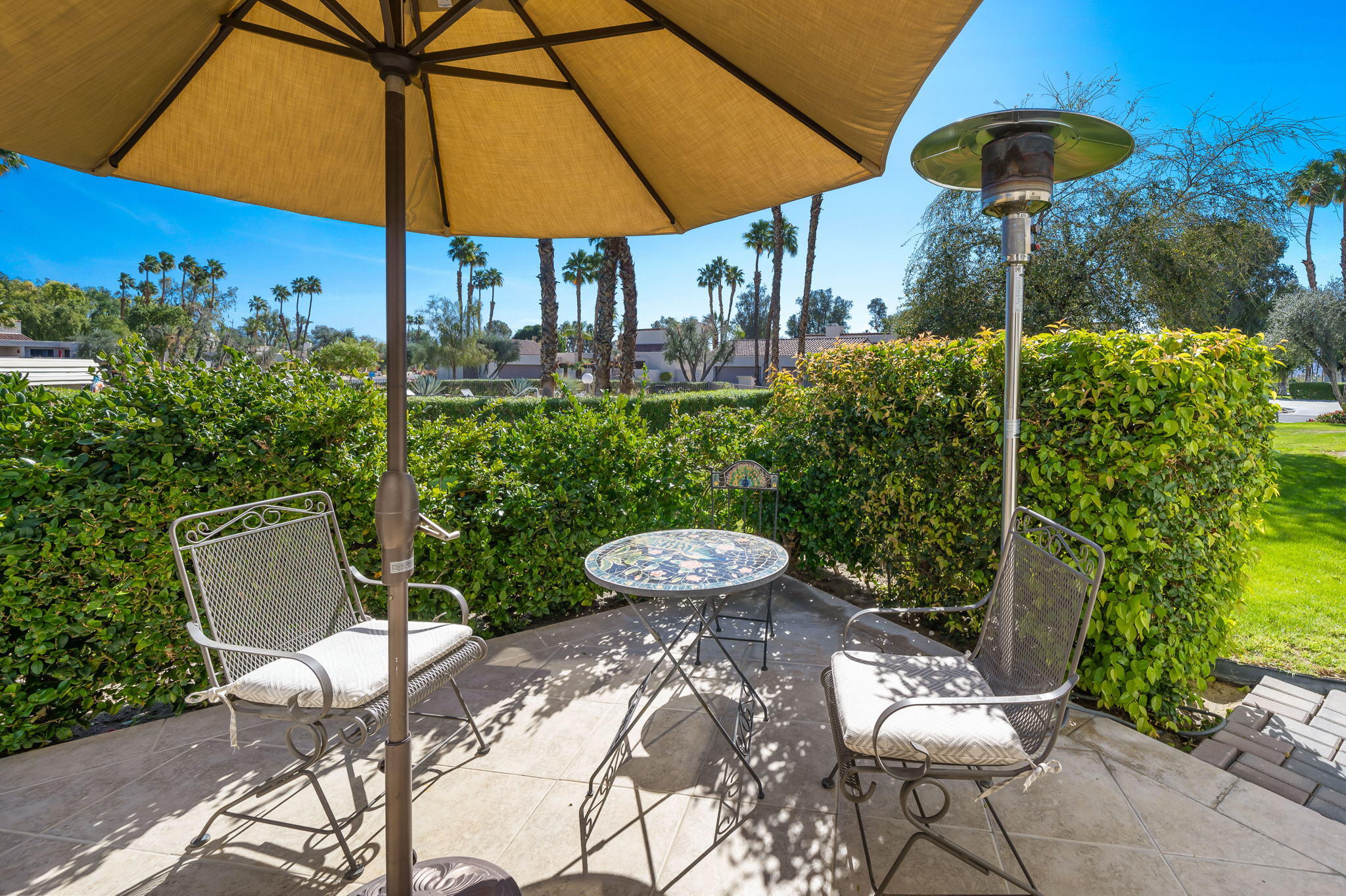 818 Inverness Drive Rancho Mirage, CA 92270 - Photo 41 of 43 a view of a chair and table under an umbrella