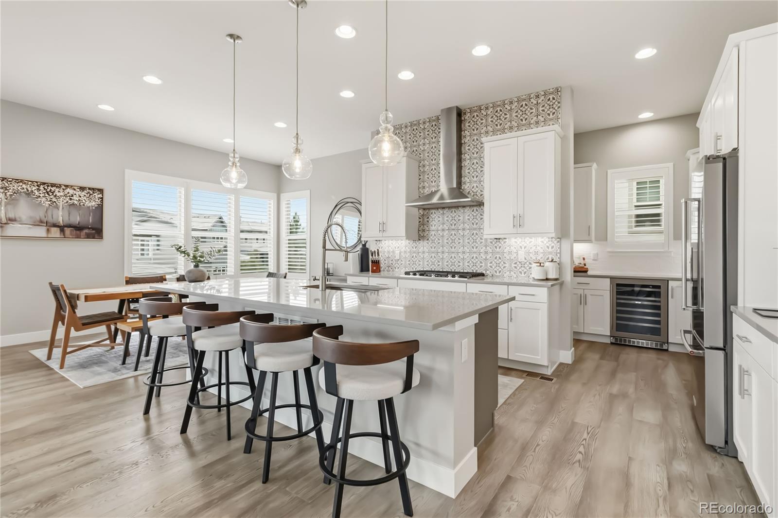 489 Meadowleaf Lane Highlands Ranch, CO 80126 - Photo 12 of 50 a kitchen with stainless steel appliances kitchen island granite countertop a table chairs sink and cabinets