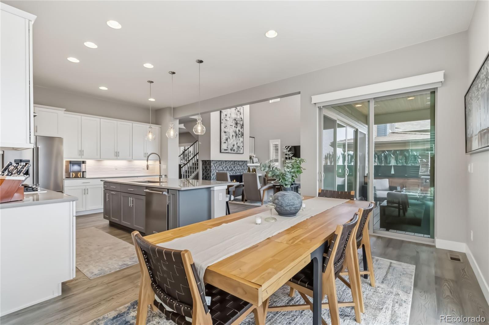489 Meadowleaf Lane Highlands Ranch, CO 80126 - Photo 14 of 50 a dining room with kitchen island furniture a large window and kitchen view