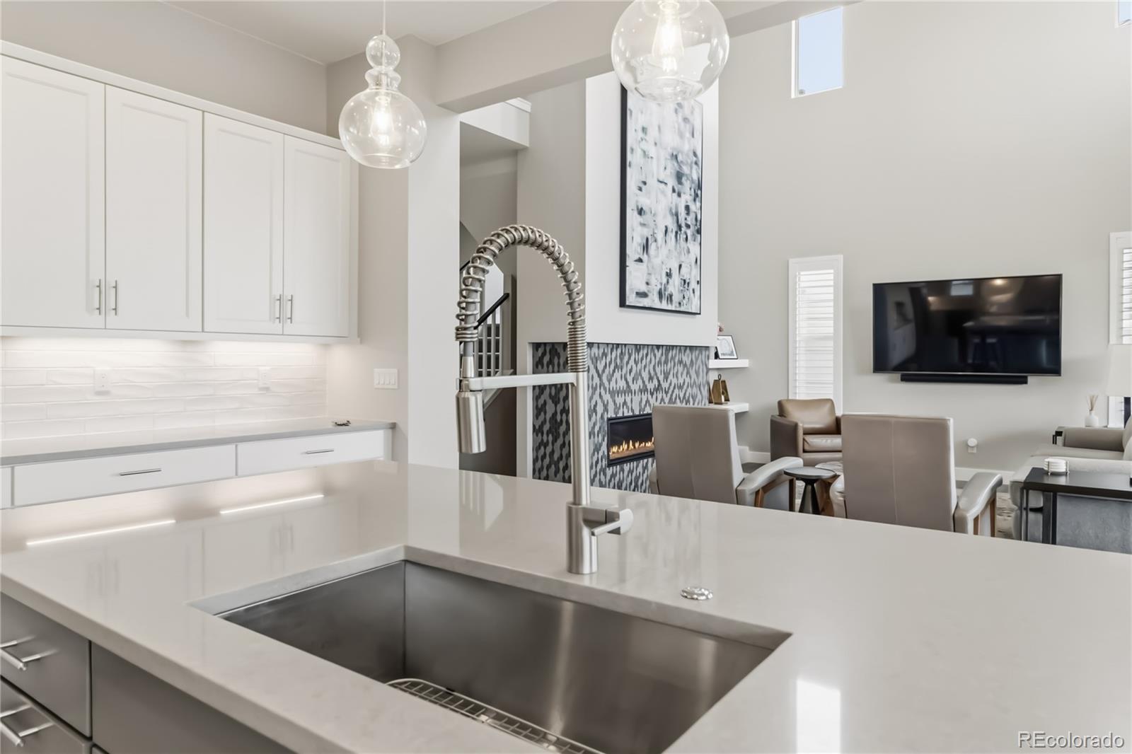 489 Meadowleaf Lane Highlands Ranch, CO 80126 - Photo 17 of 50 a kitchen with stainless steel appliances a table a microwave a refrigerator and cabinets
