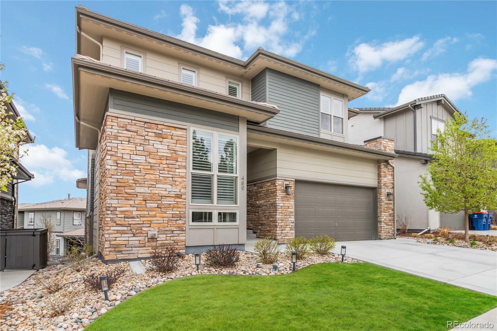 489 Meadowleaf Lane Highlands Ranch, CO 80126 - Photo 2 of 50 a front view of a house with a garden and plants