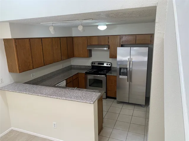 a kitchen with a sink a refrigerator and cabinets