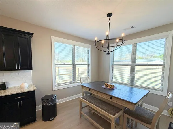 a room with table chairs and windows