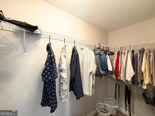 a view of walk in closet with clothes