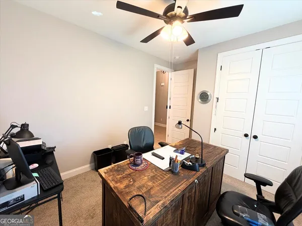 a view of a workspace with furniture and a window