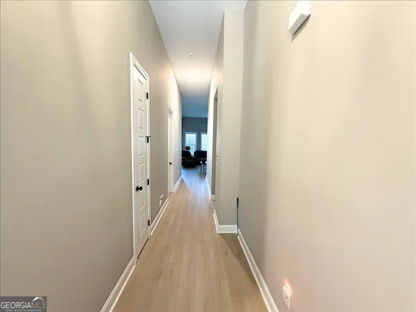 a view of a hallway with wooden floor